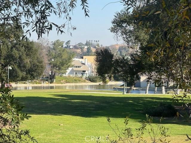 view of home's community with a water view and a yard