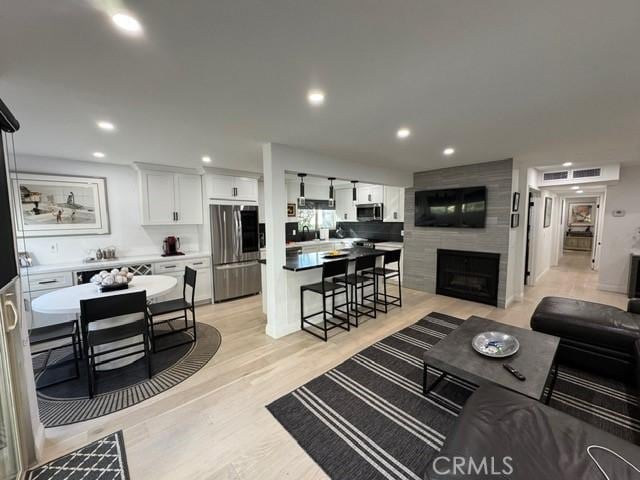 living room with a fireplace and light hardwood / wood-style flooring