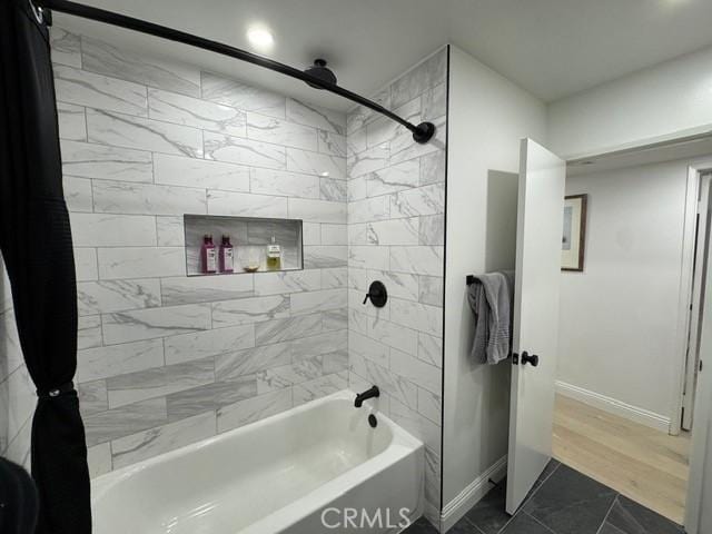 bathroom featuring tile patterned flooring and tiled shower / bath