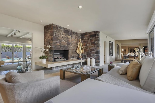 living room featuring beam ceiling and a fireplace