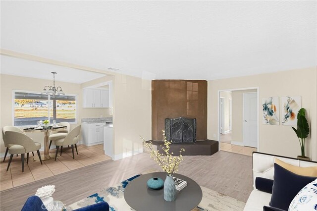 living room with light hardwood / wood-style flooring and an inviting chandelier