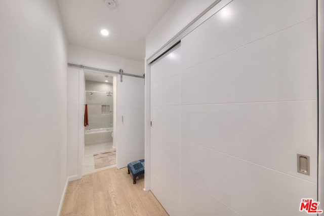 hallway featuring light hardwood / wood-style floors and a barn door