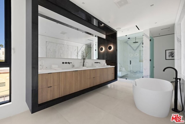 bathroom featuring vanity and independent shower and bath