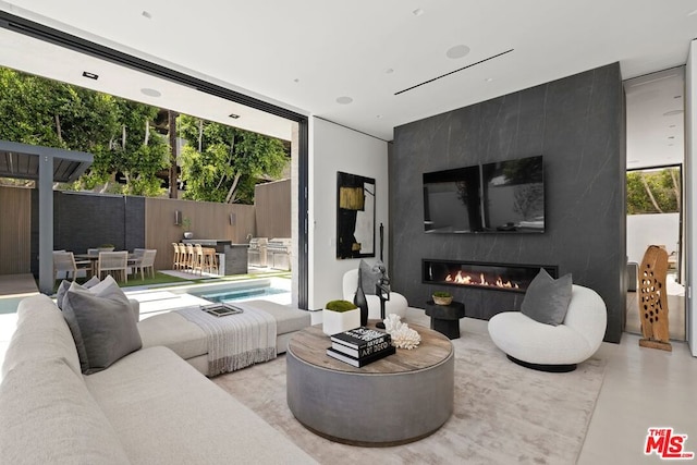 living room with a large fireplace, a healthy amount of sunlight, and expansive windows