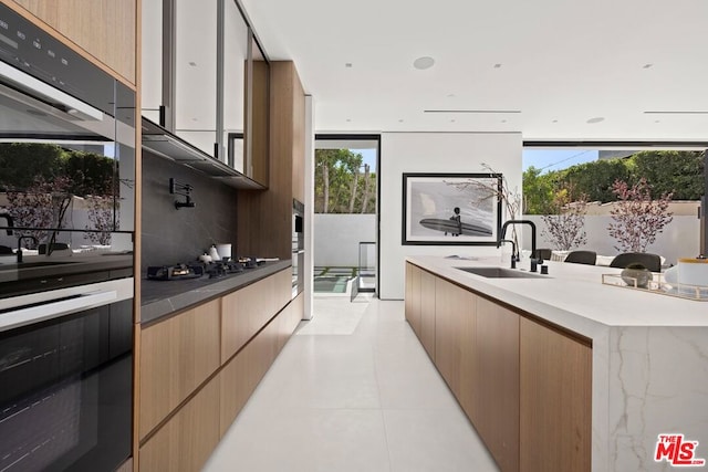 kitchen with wall oven, light tile patterned flooring, black gas stovetop, and sink