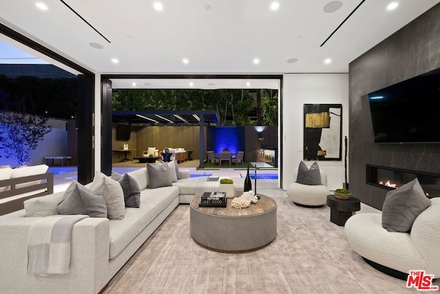 living room featuring a wall of windows and a fireplace