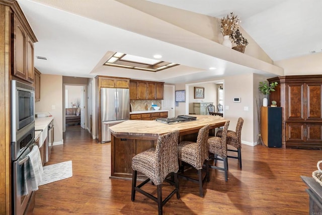 kitchen with tasteful backsplash, wooden counters, stainless steel appliances, and dark hardwood / wood-style floors