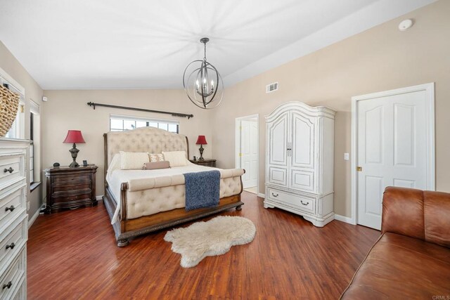 bedroom with lofted ceiling, dark wood-type flooring, and a notable chandelier