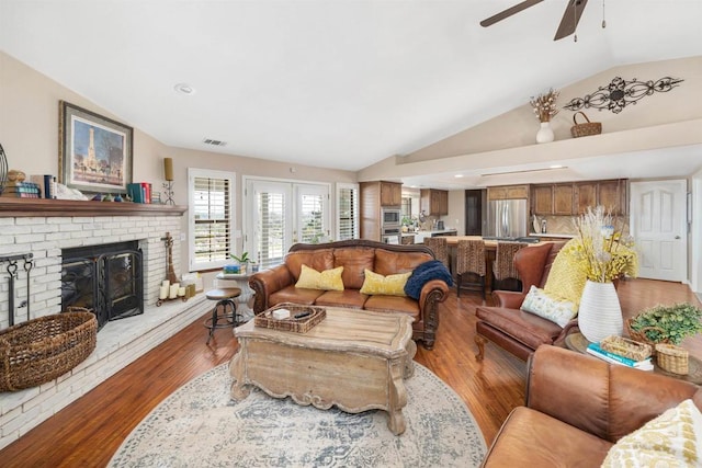 living room with vaulted ceiling, ceiling fan, a fireplace, and hardwood / wood-style flooring