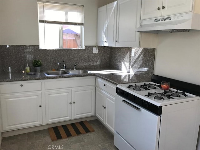 kitchen featuring decorative backsplash, sink, white cabinets, and white gas range