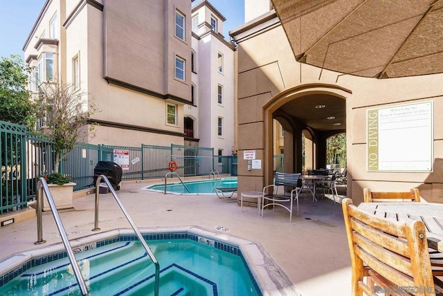 view of pool with a patio area, grilling area, and a community hot tub