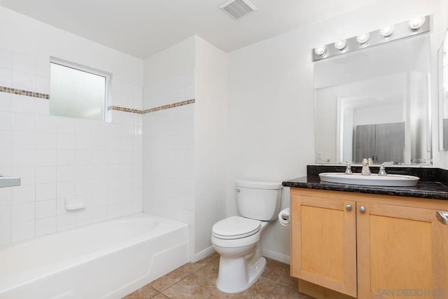 full bathroom with tile patterned flooring, vanity, tiled shower / bath, and toilet