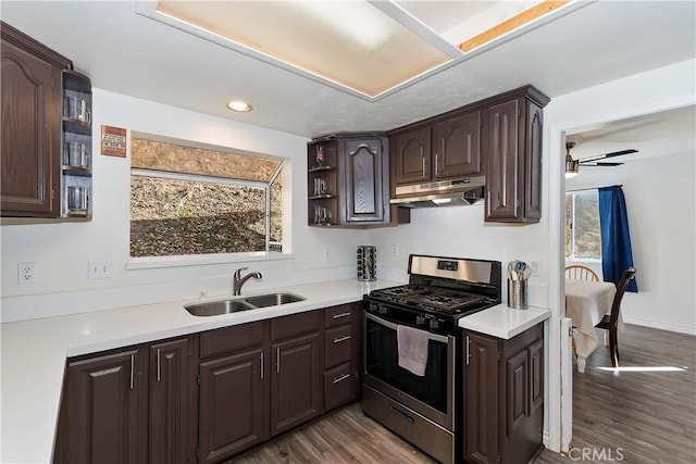 kitchen with stainless steel range with gas cooktop, ceiling fan, light wood-type flooring, dark brown cabinets, and sink