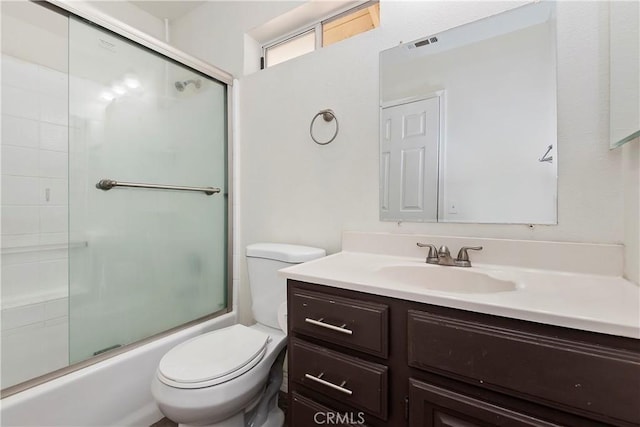 full bathroom featuring toilet, vanity, and shower / bath combination with glass door