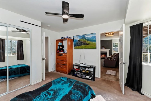 carpeted bedroom featuring ceiling fan and a closet