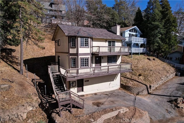 rear view of house with a deck and a garage