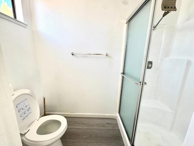 bathroom featuring hardwood / wood-style floors, toilet, and walk in shower