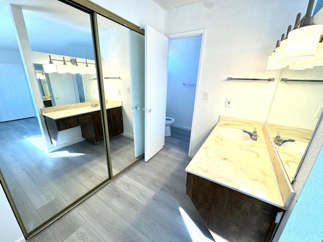 bathroom with vanity, toilet, and hardwood / wood-style floors