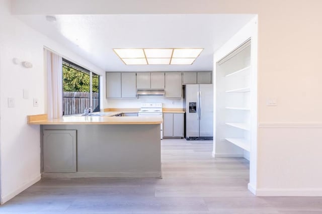 kitchen with white electric range, kitchen peninsula, gray cabinetry, and stainless steel refrigerator with ice dispenser