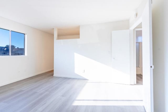 unfurnished room with light wood-type flooring