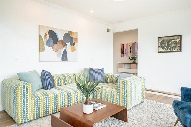 living room featuring wood-type flooring and crown molding