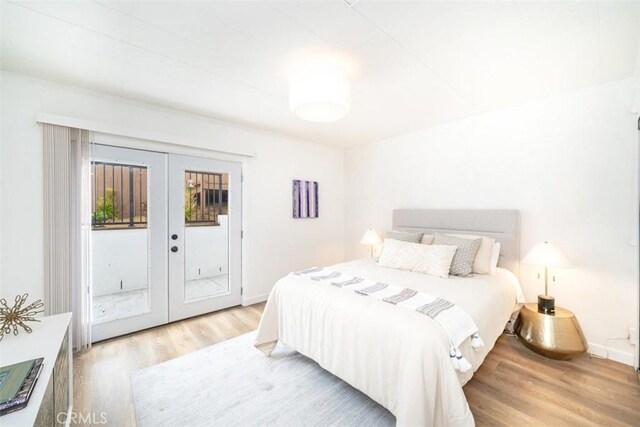 bedroom with access to exterior, light hardwood / wood-style flooring, and french doors