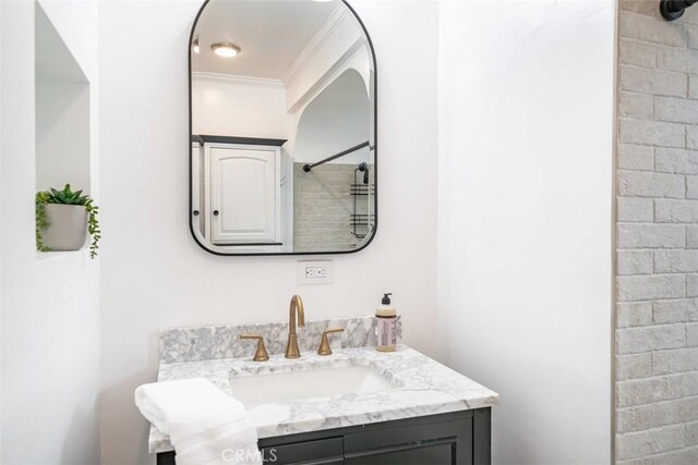 bathroom featuring vanity, a shower, and ornamental molding