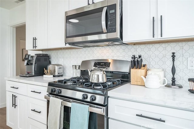 kitchen featuring white cabinetry, tasteful backsplash, and appliances with stainless steel finishes