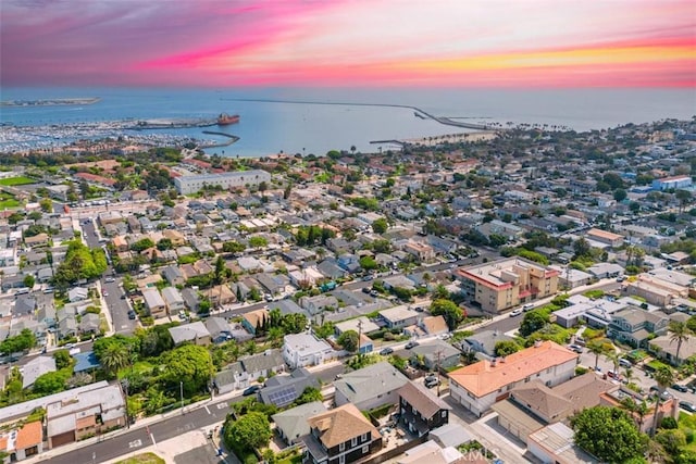 aerial view at dusk featuring a water view