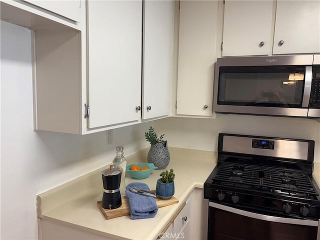 kitchen featuring stainless steel appliances and white cabinetry