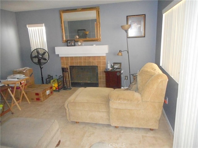 living room with light tile patterned floors and a tile fireplace