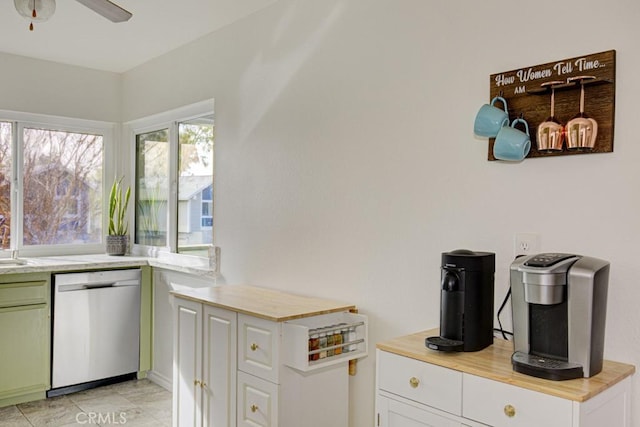 kitchen featuring white cabinets, sink, ceiling fan, butcher block countertops, and stainless steel dishwasher