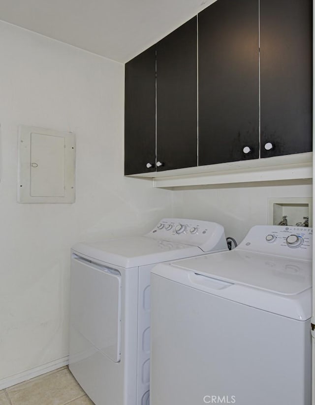 laundry area with light tile patterned floors, cabinets, electric panel, and separate washer and dryer