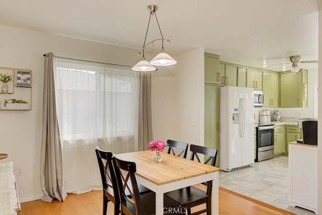 dining area with ceiling fan and light wood-type flooring