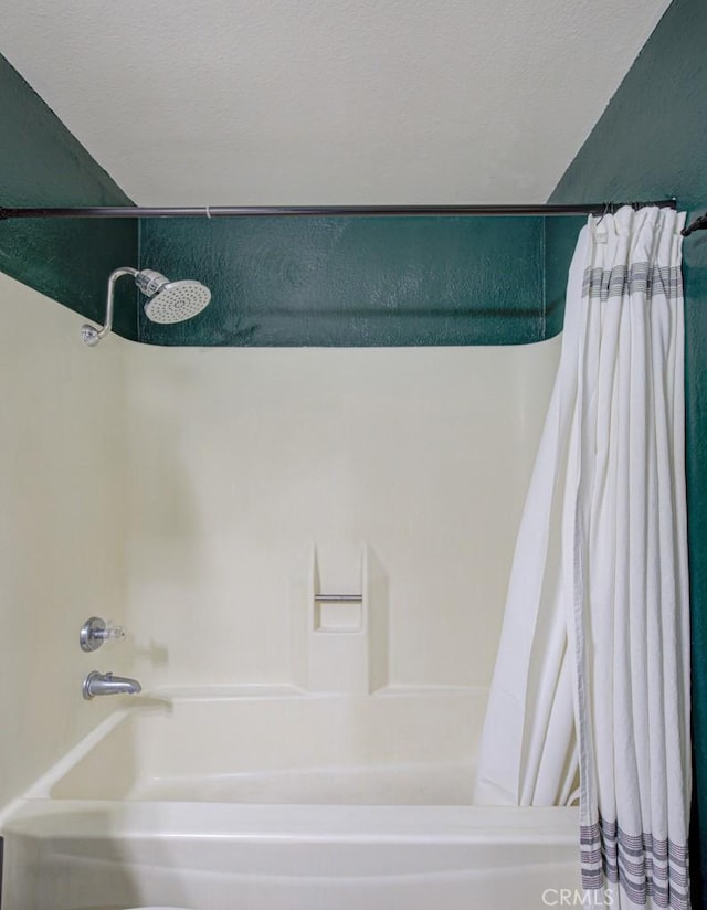 bathroom with a textured ceiling and shower / tub combo