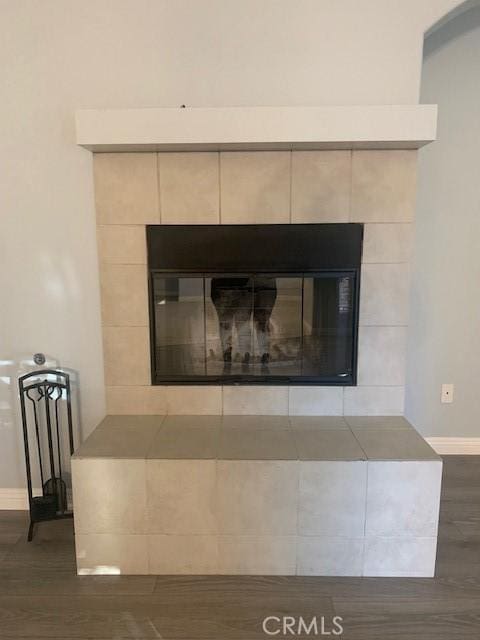 room details with hardwood / wood-style flooring and a tiled fireplace