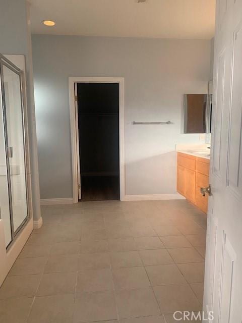 bathroom with walk in shower, tile patterned floors, and vanity