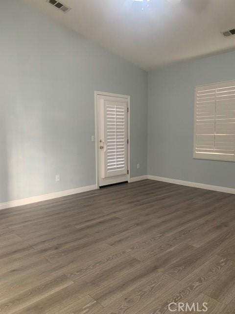 unfurnished room featuring lofted ceiling and hardwood / wood-style floors