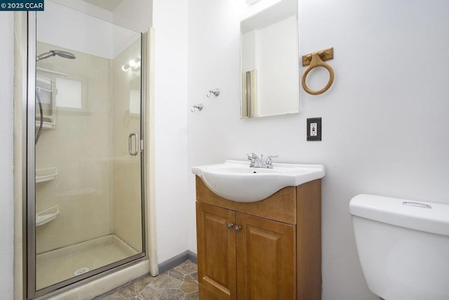 bathroom featuring an enclosed shower, vanity, and toilet