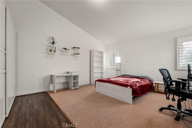 bedroom with lofted ceiling and hardwood / wood-style floors