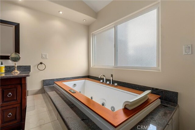 bathroom with vanity, vaulted ceiling, tile patterned floors, and a bathing tub