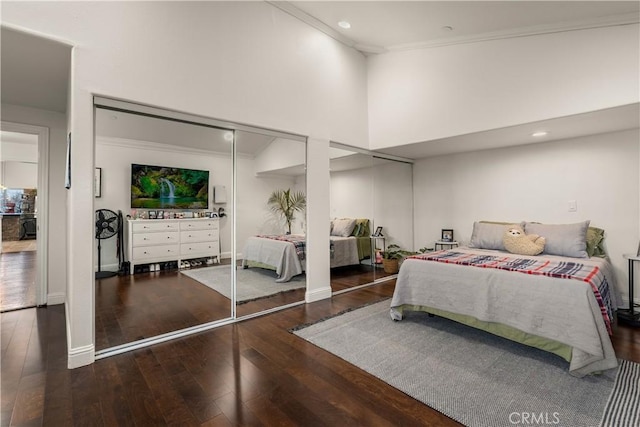 bedroom with hardwood / wood-style floors and a towering ceiling