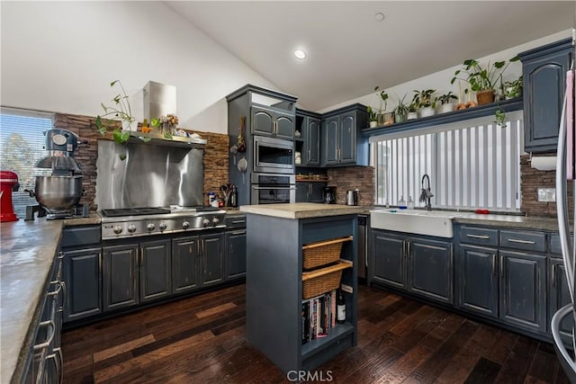 kitchen with dark wood-type flooring, appliances with stainless steel finishes, lofted ceiling, and tasteful backsplash