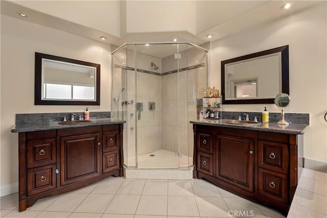 bathroom featuring a shower with door, vanity, and tile patterned flooring