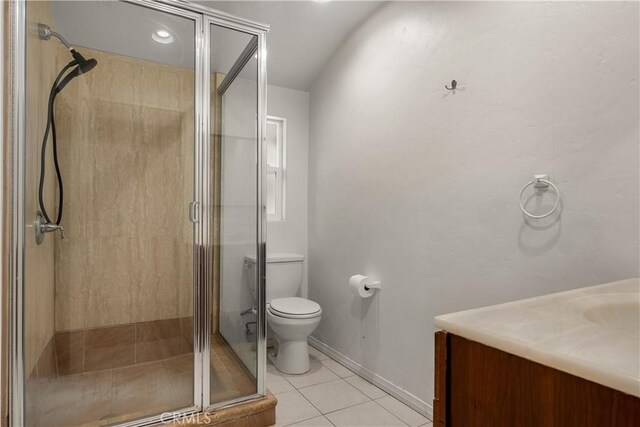 bathroom featuring a shower with shower door, vanity, tile patterned flooring, and toilet