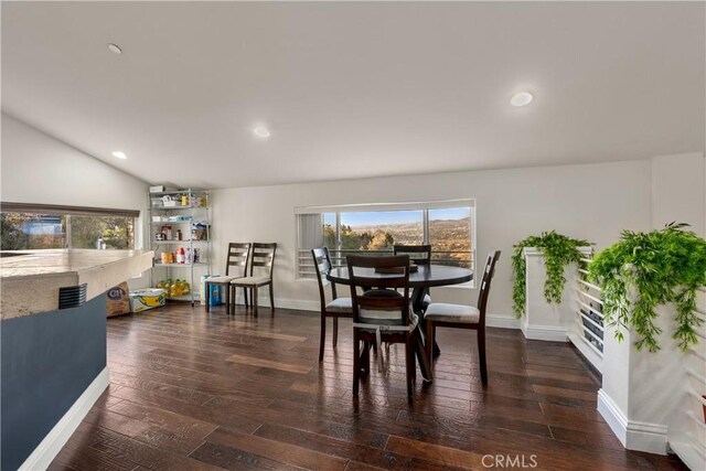 dining space featuring dark hardwood / wood-style floors and vaulted ceiling