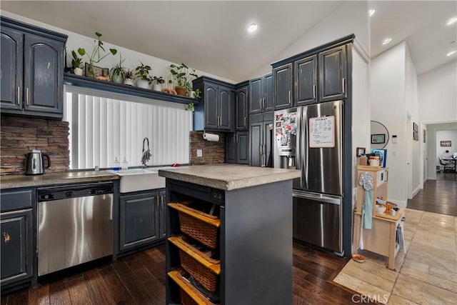 kitchen with appliances with stainless steel finishes, dark hardwood / wood-style flooring, backsplash, and a center island