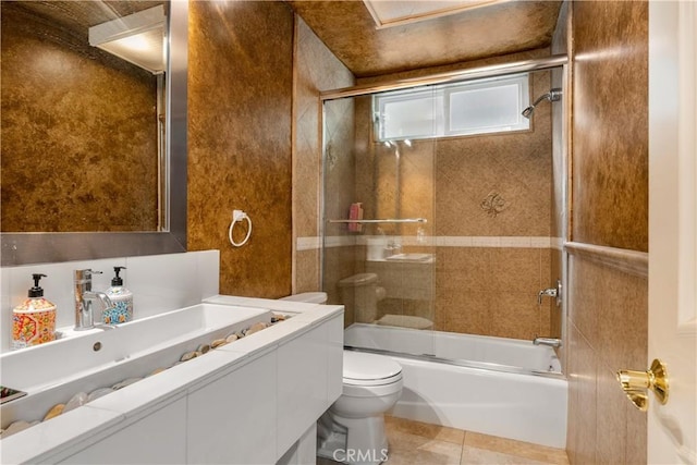 full bathroom featuring tile patterned floors, bath / shower combo with glass door, toilet, and vanity