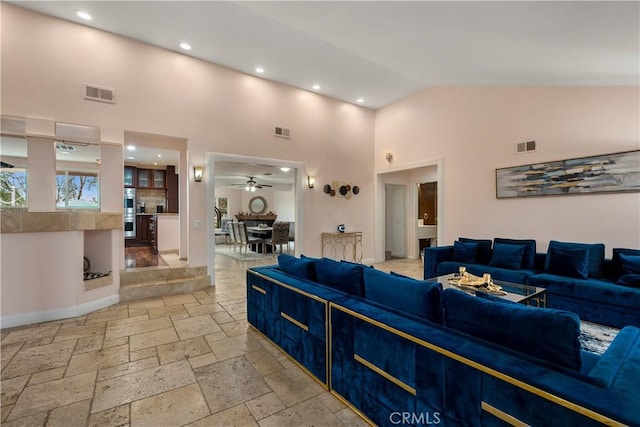 living room featuring ceiling fan and high vaulted ceiling