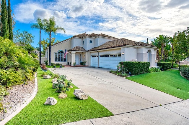 mediterranean / spanish home featuring a front yard and a garage